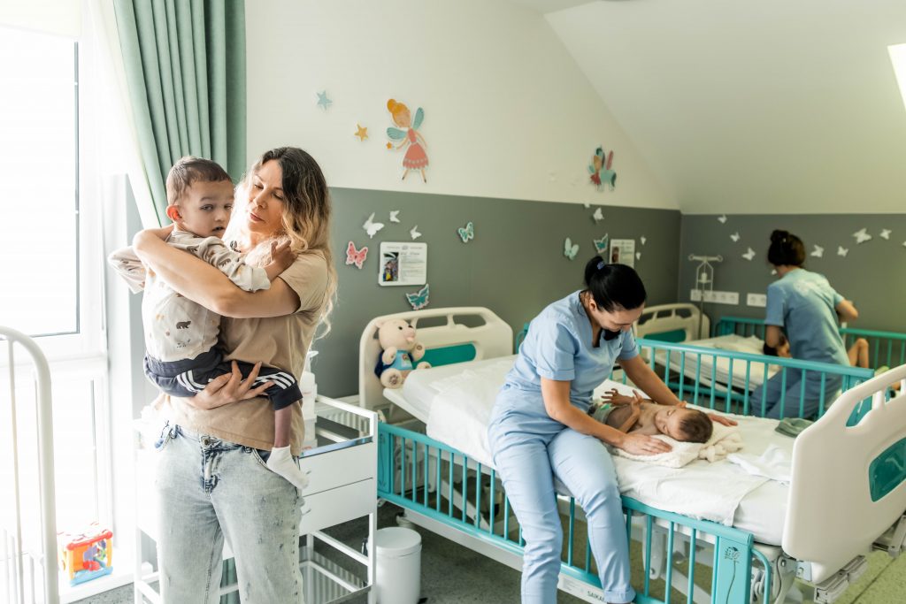 Children in hospital ward with care workers